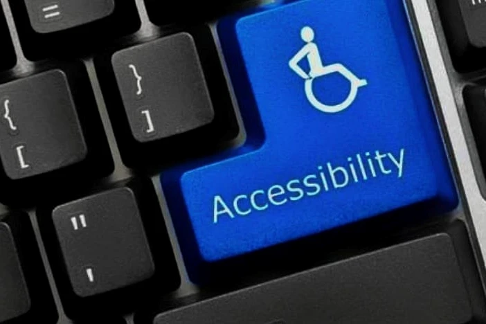 A close-up of a computer keyboard with a blue “Accessibility” key featuring a wheelchair icon