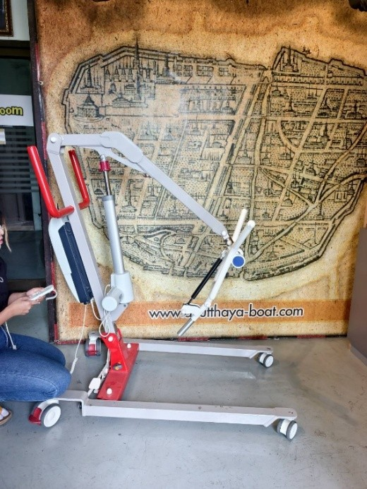 Patient hoist with sling attached in use