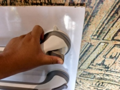 Shower grab bar being attached to wall by hand