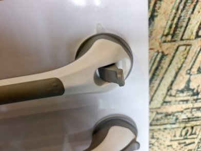 Close-up of shower grab bar lock mechanism on white wall