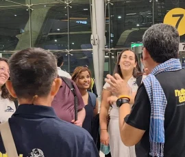 The journey begins—warm welcomes and shared excitement on arrival day Group of people at the airport; logo on shirts: Accessible Thailand.