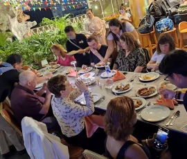 A joyful beginning—shared meals and warm connections on the first day of our accessible journey Group of blind people dining together at a restaurant, surrounded by food and drinks.
