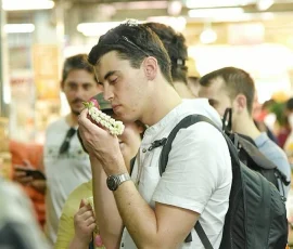 Bangkok’s flower market through scent and touch—an inclusive sensory experience for all A blind traveler smelling a jasmine garland in a lively indoor flower market in Bangkok