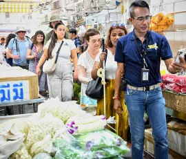 Bangkok’s iconic flower market—where scent, texture, and tradition welcome every traveler A tour guide leading blind travelers through Pak Khlong Talat flower market, surrounded by garlands and fresh blooms