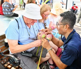 Hands-on heritage—exploring Buddhist traditions through inclusive flower-folding at Wat Po A blind traveler learning to fold lotus flowers during a guided cultural activity at Wat Po temple