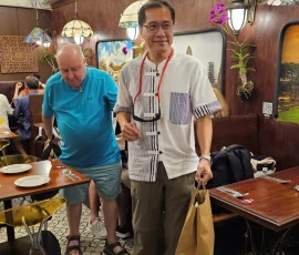 After the market—relaxing in a colorful café with local flavors and friendly vibes A traveler holding a paper bag and drink inside a vibrant restaurant near Chatuchak Market