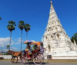 Discover Chiang Mai’s timeless charm through inclusive travel experiences that honor heritage and accessibility A horse-drawn carriage passing a white tiered pagoda with intricate carvings in Chiang Mai